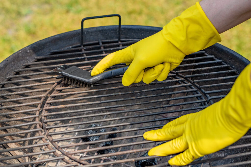 Cleaning the grill grate with a metal brush closeup